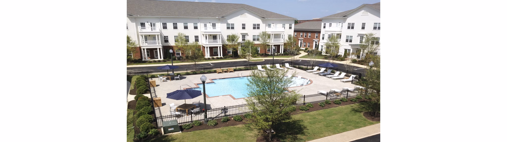 Luxury outdoor pool at Carrington at Schilling Farms Apartments with lounge chairs and lush landscaping