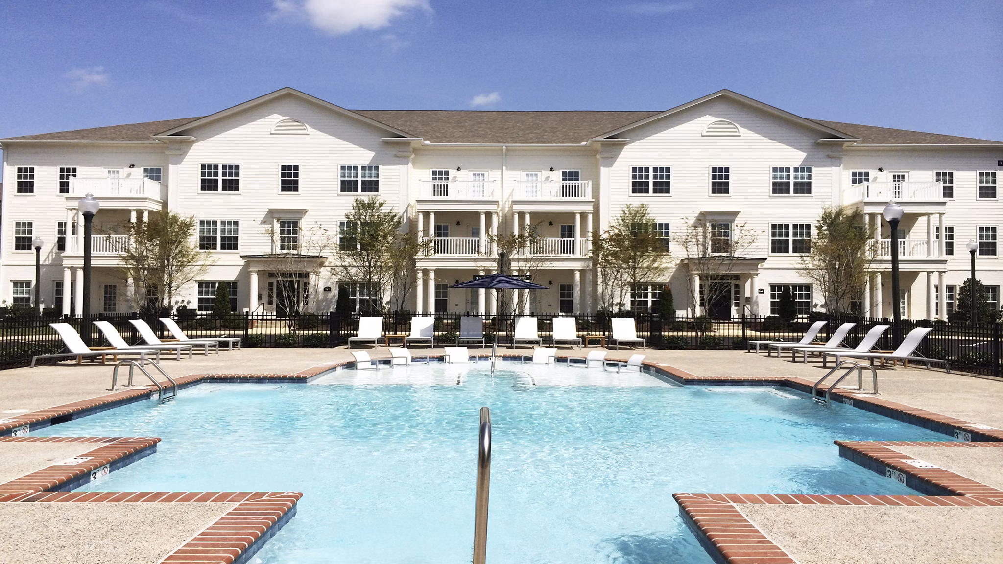 Relaxing pool with lounge chairs at Carrington at Schilling Farms Apartments, perfect for unwinding in a luxury setting