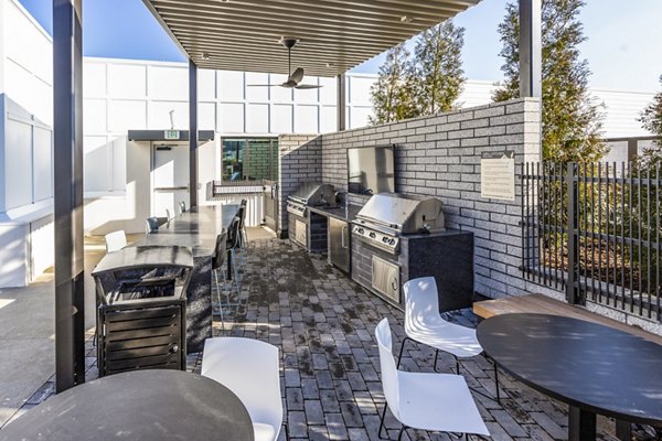 Outdoor grill area with modern seating at Novel Edgehill Apartments, Nashville - ideal for social gatherings and barbecues