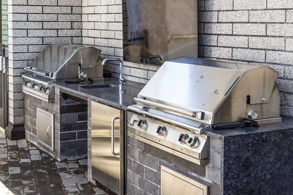 Outdoor grill area with modern seating at Novel Edgehill Apartments, offering luxury apartment living in a vibrant community setting