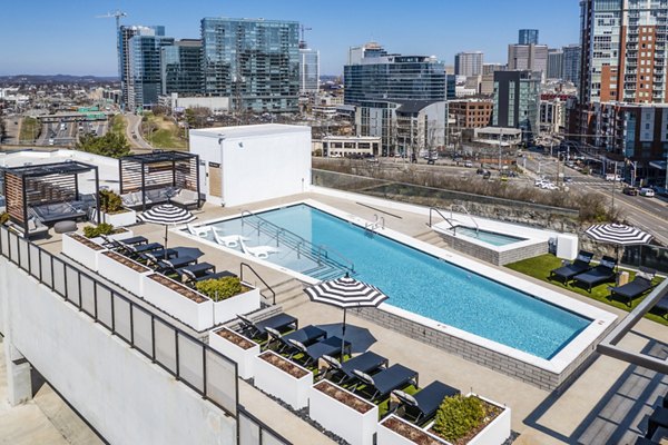 Modern outdoor pool surrounded by sleek lounging chairs at Novel Edgehill Apartments, enhancing luxury living experience
