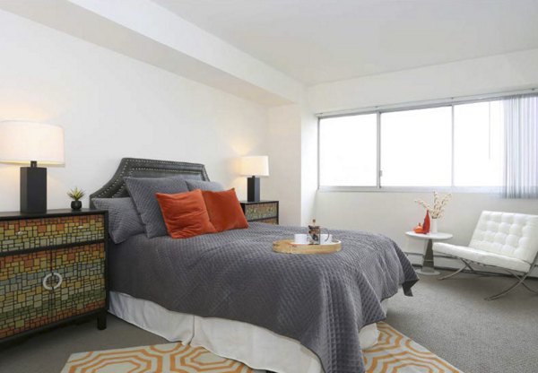 Modern bedroom with large windows and neutral decor at Cathedral Hill Plaza Apartments