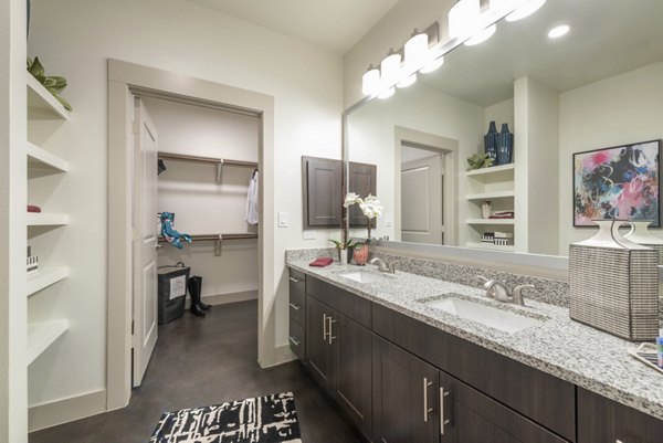 Modern bathroom with marble countertops and elegant fixtures in Alexan Flower Mound Apartments