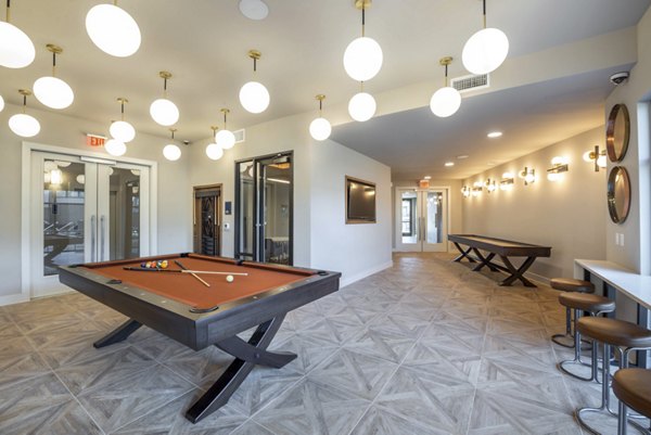 Modern clubhouse featuring a full kitchen and lounge at Alexan Flower Mound Apartments