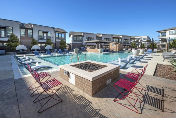 Resort-style pool with lounge chairs at Alexan Flower Mound Apartments, perfect for relaxation and recreation in a luxury setting