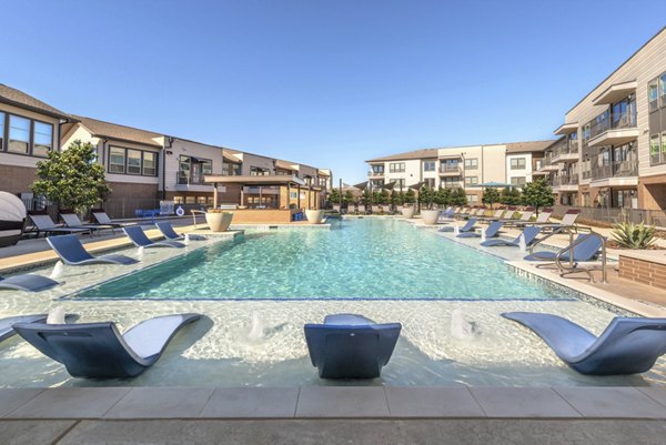 Infinity-edge pool at Alexan Flower Mound Apartments offering luxury living and scenic views