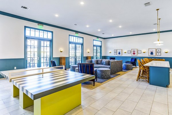 Modern clubhouse game room with pool table and seating at Town Center at Berry Farms Apartments