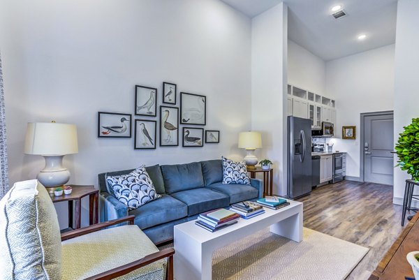 Open-concept living room with stylish decor in Town Center at Berry Farms Apartments, featuring plush seating and natural light