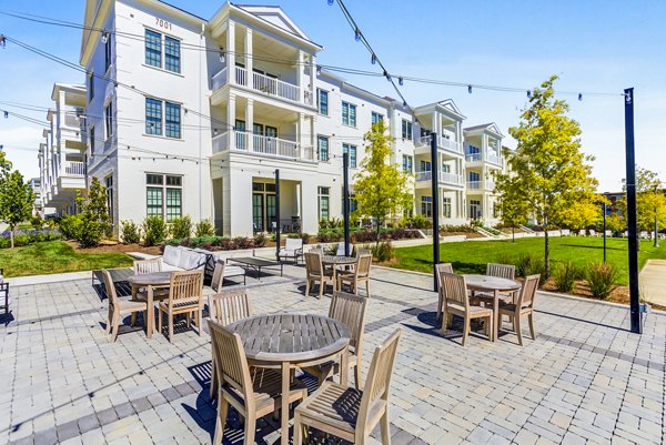 Spacious outdoor patio at Town Center at Berry Farms Apartments, featuring comfortable seating and lush greenery, perfect for relaxation and gatherings
