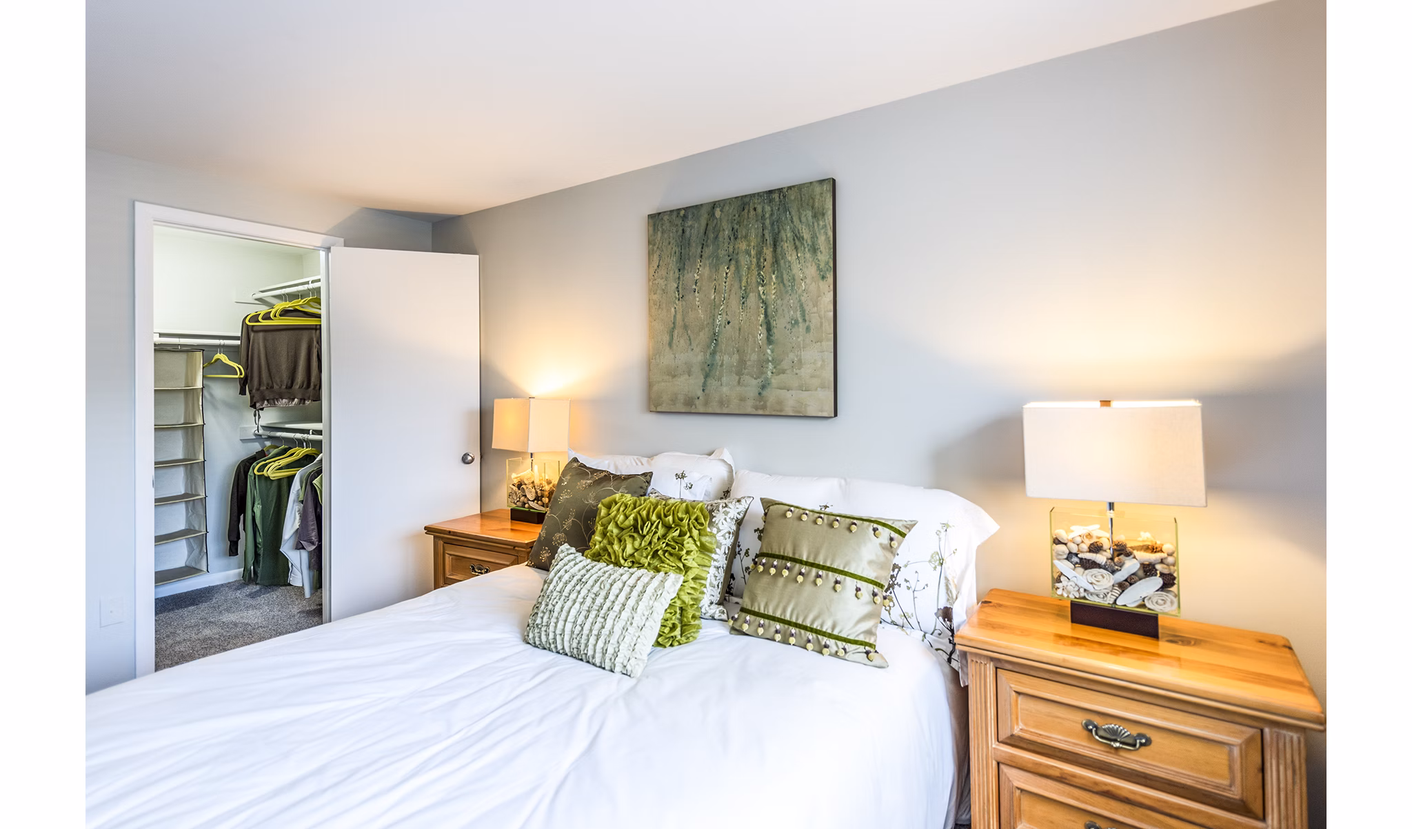 Bedroom featuring plush bedding and natural lighting in Ravens Crest Apartments, a Greystar luxury apartment community