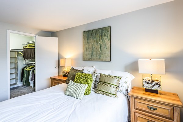 Bedroom featuring plush bedding and natural lighting in Ravens Crest Apartments, a Greystar luxury apartment community