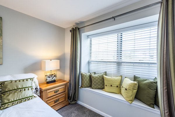 Cozy bedroom with contemporary decor at Ravens Crest Apartments featuring luxury living spaces