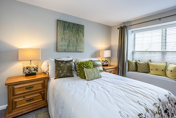 Cozy bedroom with large window at Ravens Crest Apartments, luxury living in a tranquil setting