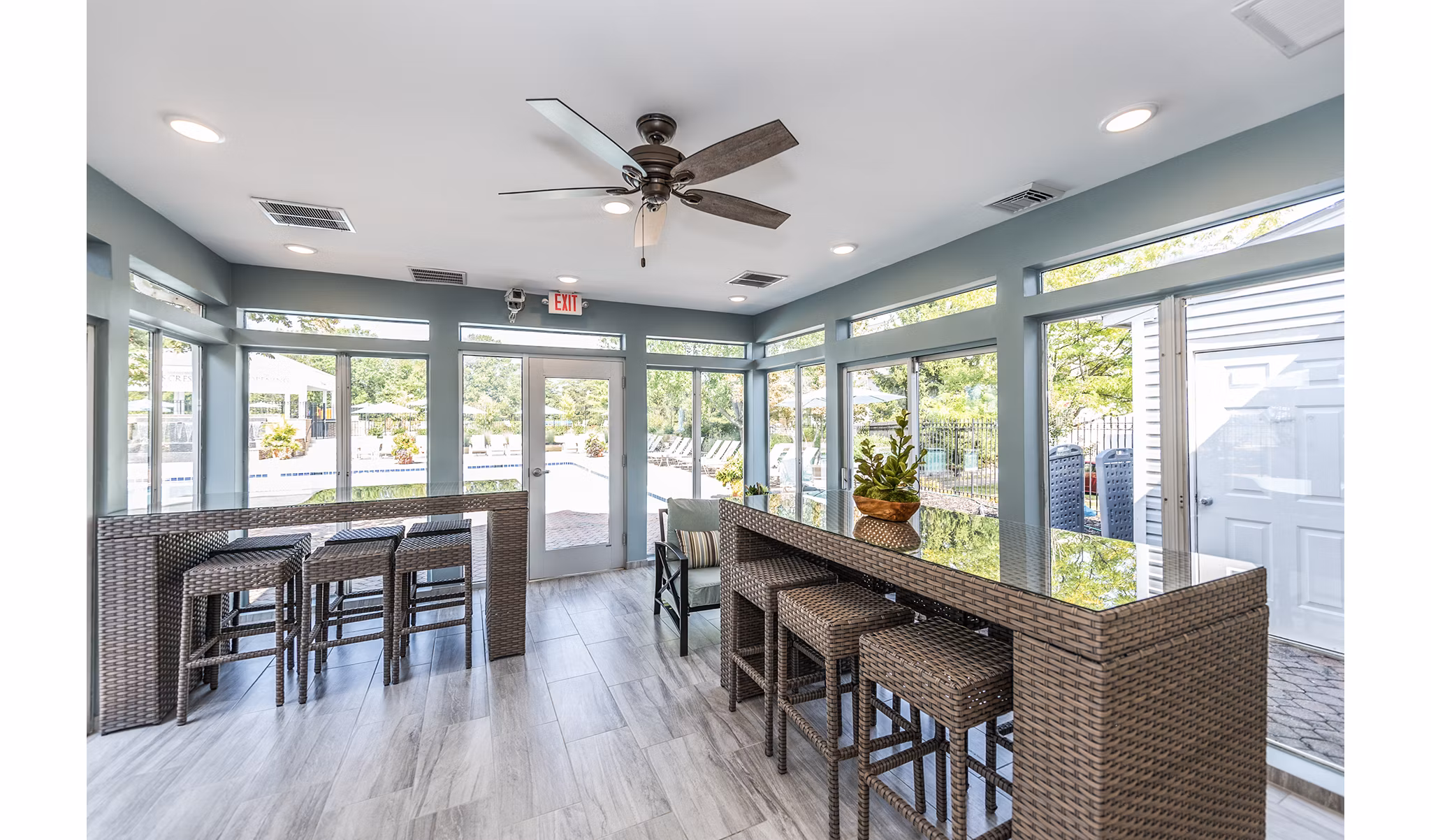 Clubhouse patio with modern furniture and greenery at Ravens Crest Apartments offering luxury living spaces