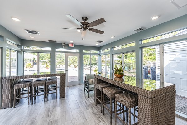 Clubhouse patio with modern furniture and greenery at Ravens Crest Apartments offering luxury living spaces