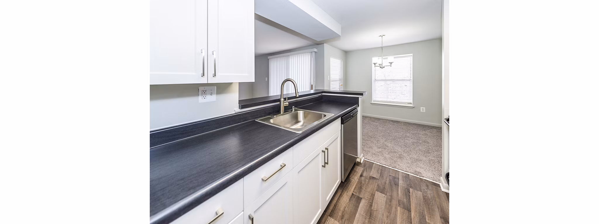 Modern kitchen with stainless steel appliances at Ravens Crest Apartments, featuring sleek countertops and ample storage space
