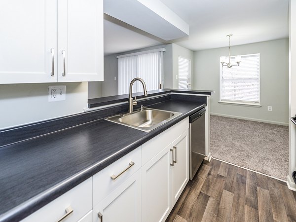 Modern kitchen with stainless steel appliances at Ravens Crest Apartments, featuring sleek countertops and ample storage space