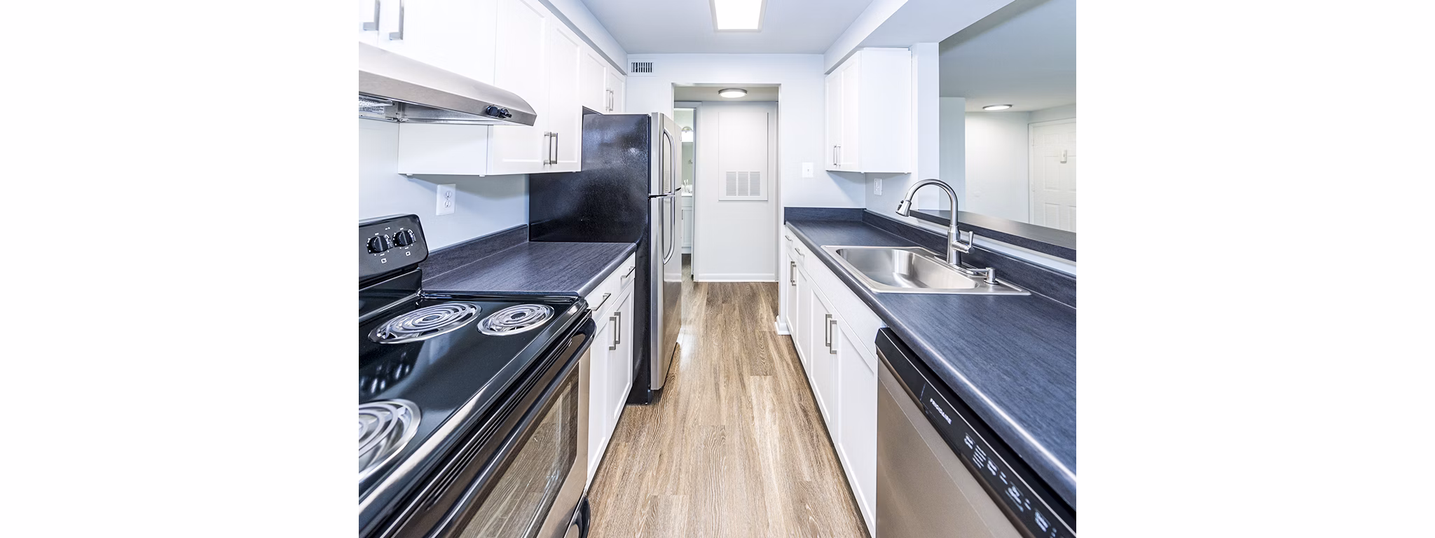 Modern kitchen with stainless steel appliances and granite countertops at Ravens Crest Apartments
