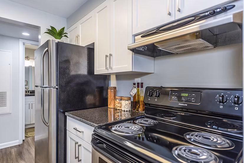 Modern kitchen with stainless steel appliances and granite countertops in Ravens Crest Apartments, calling you to stylish living