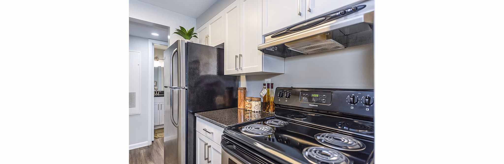 Modern kitchen with stainless steel appliances and granite countertops in Ravens Crest Apartments, calling you to stylish living