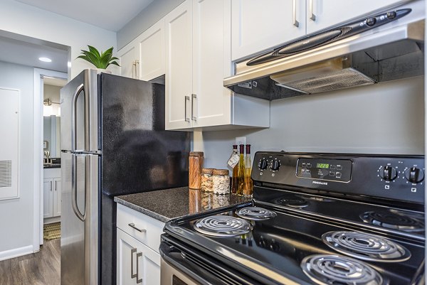 Modern kitchen with stainless steel appliances and granite countertops in Ravens Crest Apartments, calling you to stylish living