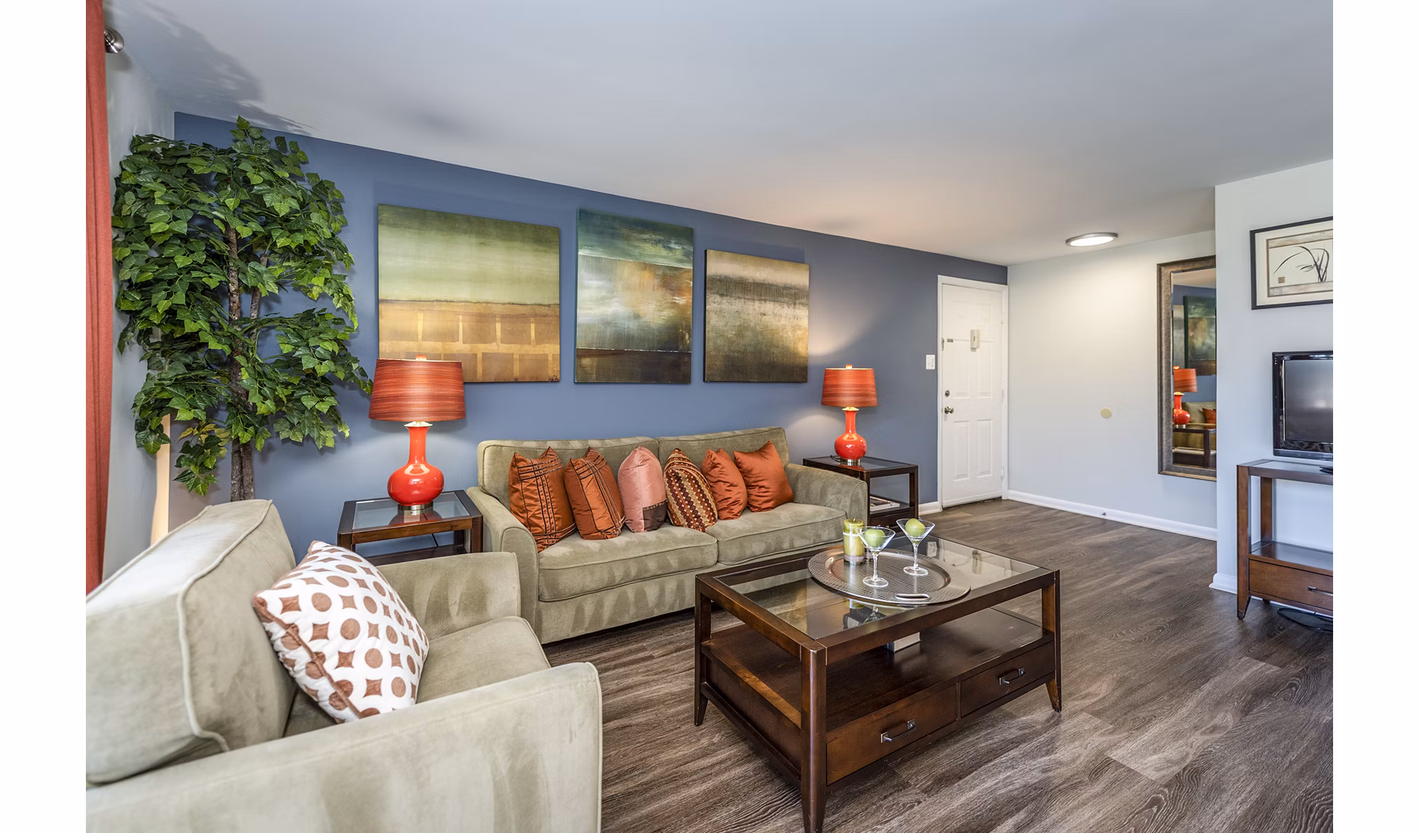 Spacious living room with modern decor and large windows at Ravens Crest Apartments