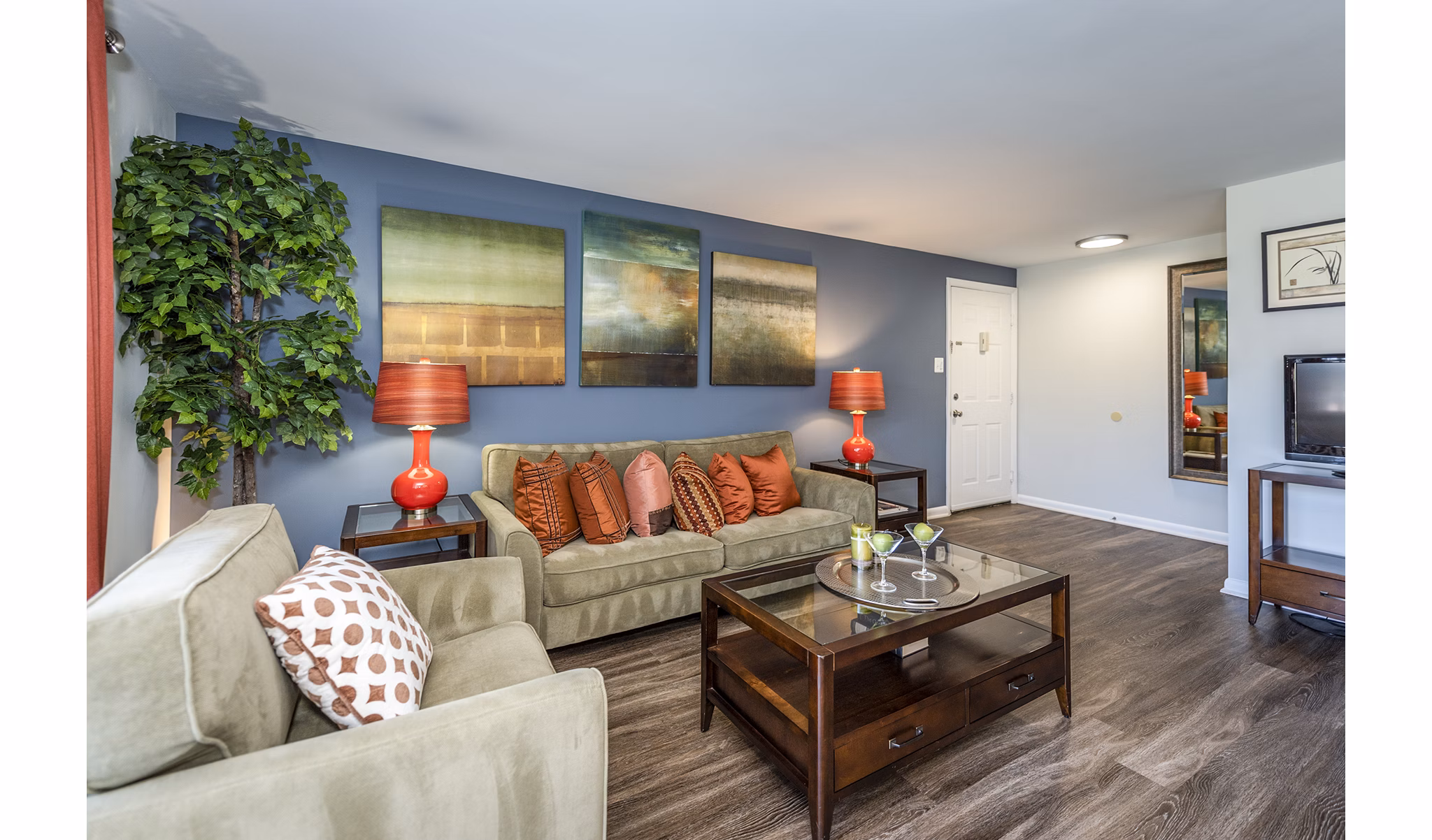 Spacious living room with modern decor and large windows at Ravens Crest Apartments
