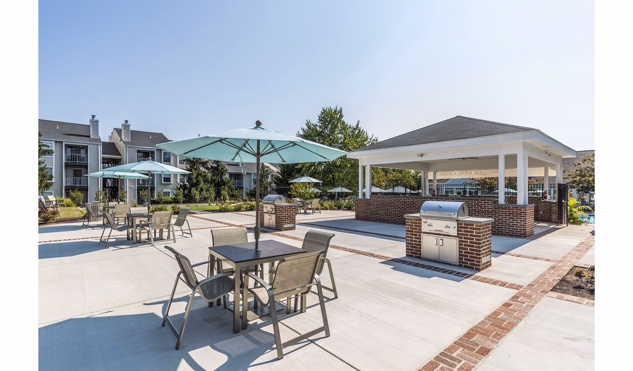 Outdoor grill area with modern seating at Ravens Crest Apartments, ideal for social gatherings and dining al fresco