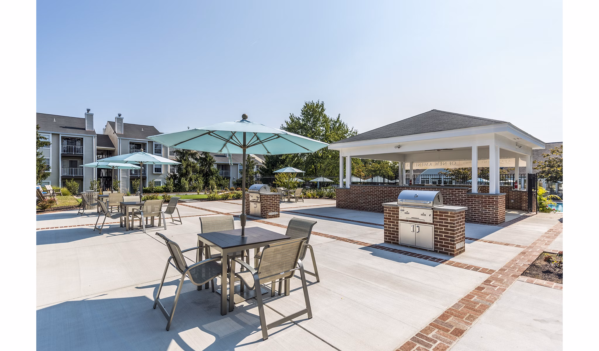 Outdoor grill area with modern seating at Ravens Crest Apartments, ideal for social gatherings and dining al fresco