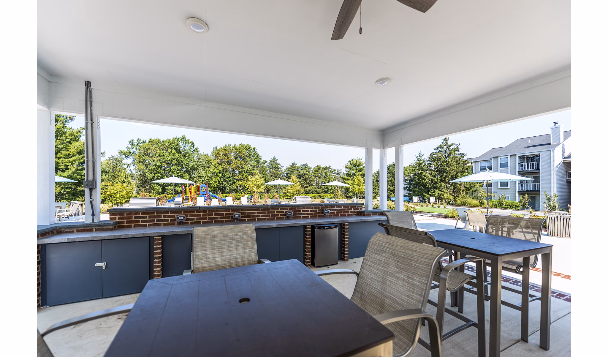 Poolside relaxation area with grills at Ravens Crest Apartments offering luxury outdoor amenities
