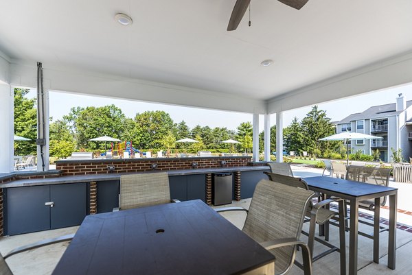 Poolside relaxation area with grills at Ravens Crest Apartments offering luxury outdoor amenities