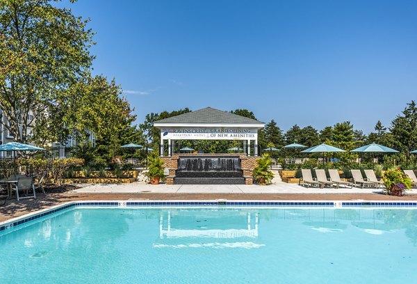 Resort-style pool with loungers at Ravens Crest Apartments