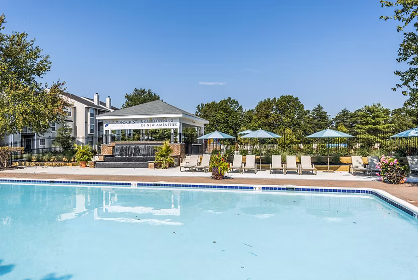 Expansive swimming pool area with loungers at Ravens Crest Apartments for relaxation and leisure