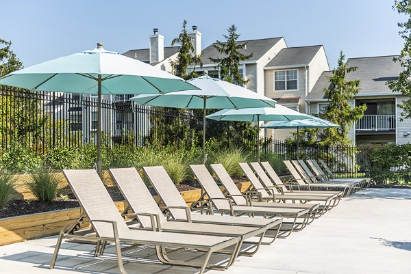 Relaxing poolside lounge chairs at Ravens Crest Apartments