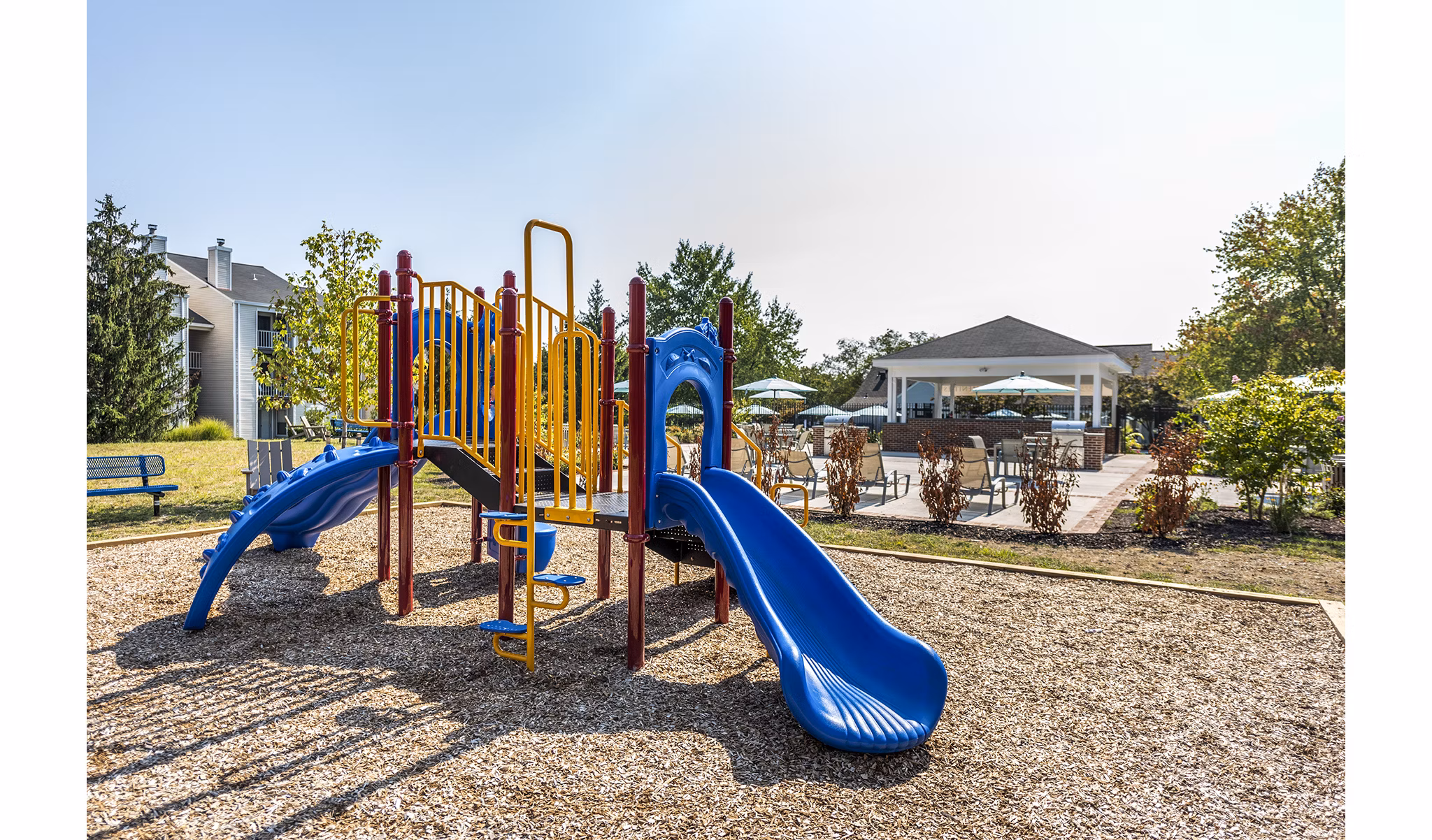 Modern playground with colorful equipment at Ravens Crest Apartments, ideal for family fun and outdoor play in a vibrant community setting