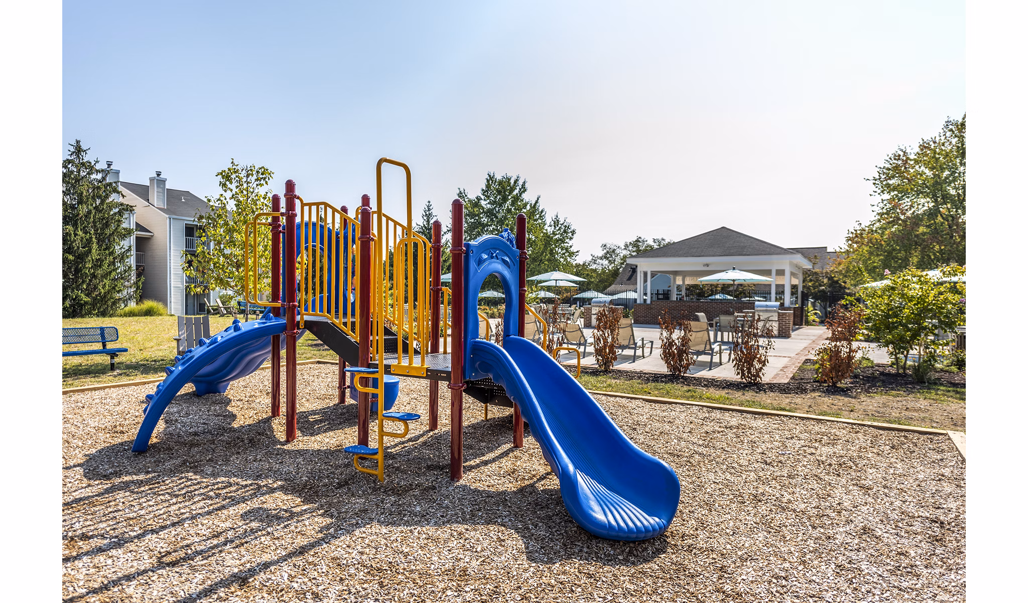 Modern playground with colorful equipment at Ravens Crest Apartments, ideal for family fun and outdoor play in a vibrant community setting
