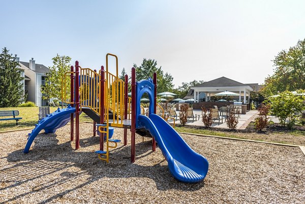 Modern playground with colorful equipment at Ravens Crest Apartments, ideal for family fun and outdoor play in a vibrant community setting