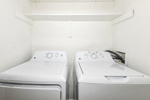 Laundry room with modern washers and dryers at Avana Chase Apartments, a Greystar community