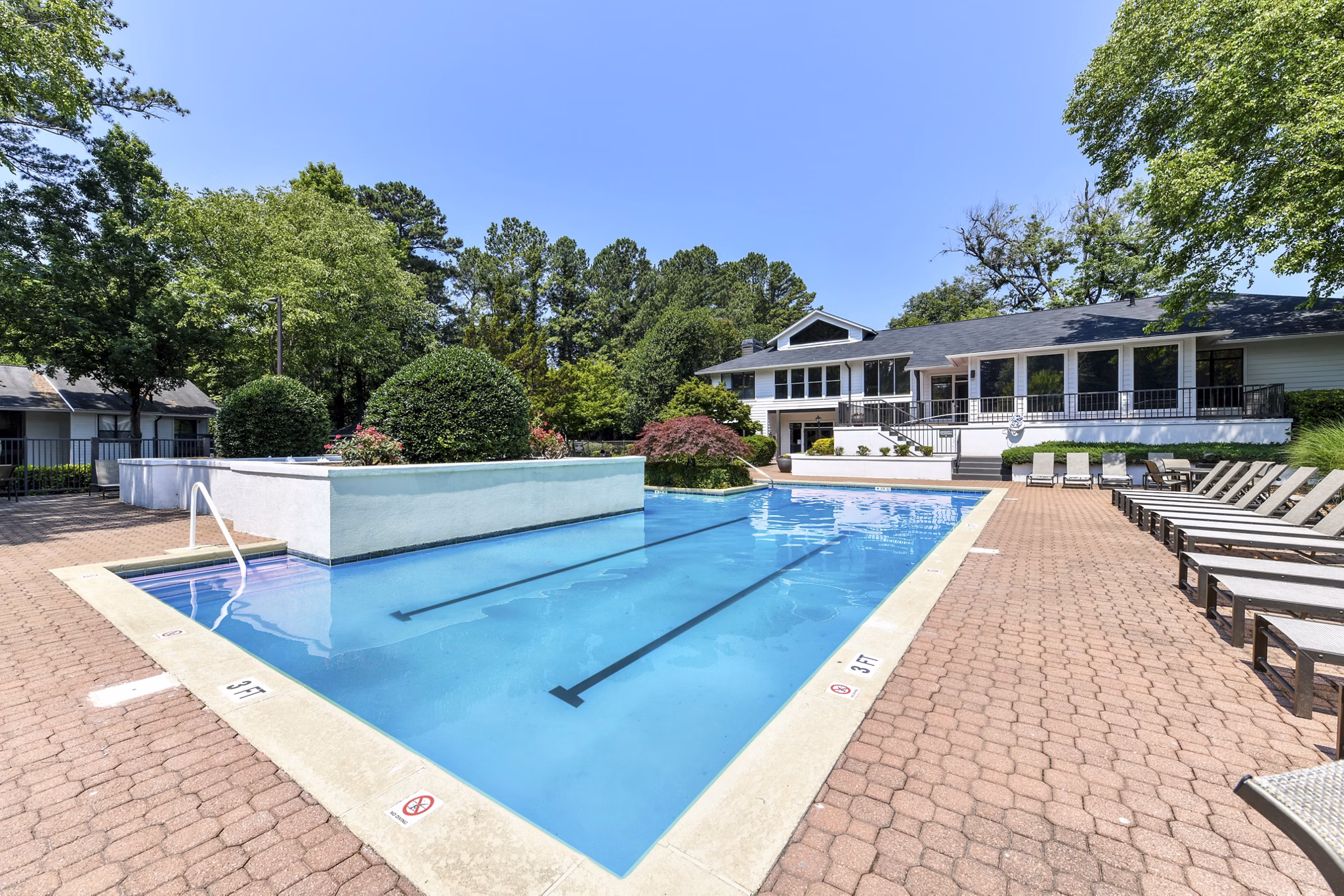 Serene outdoor pool at Avana Chase Apartments with lush landscaping, perfect for relaxation in a luxury setting