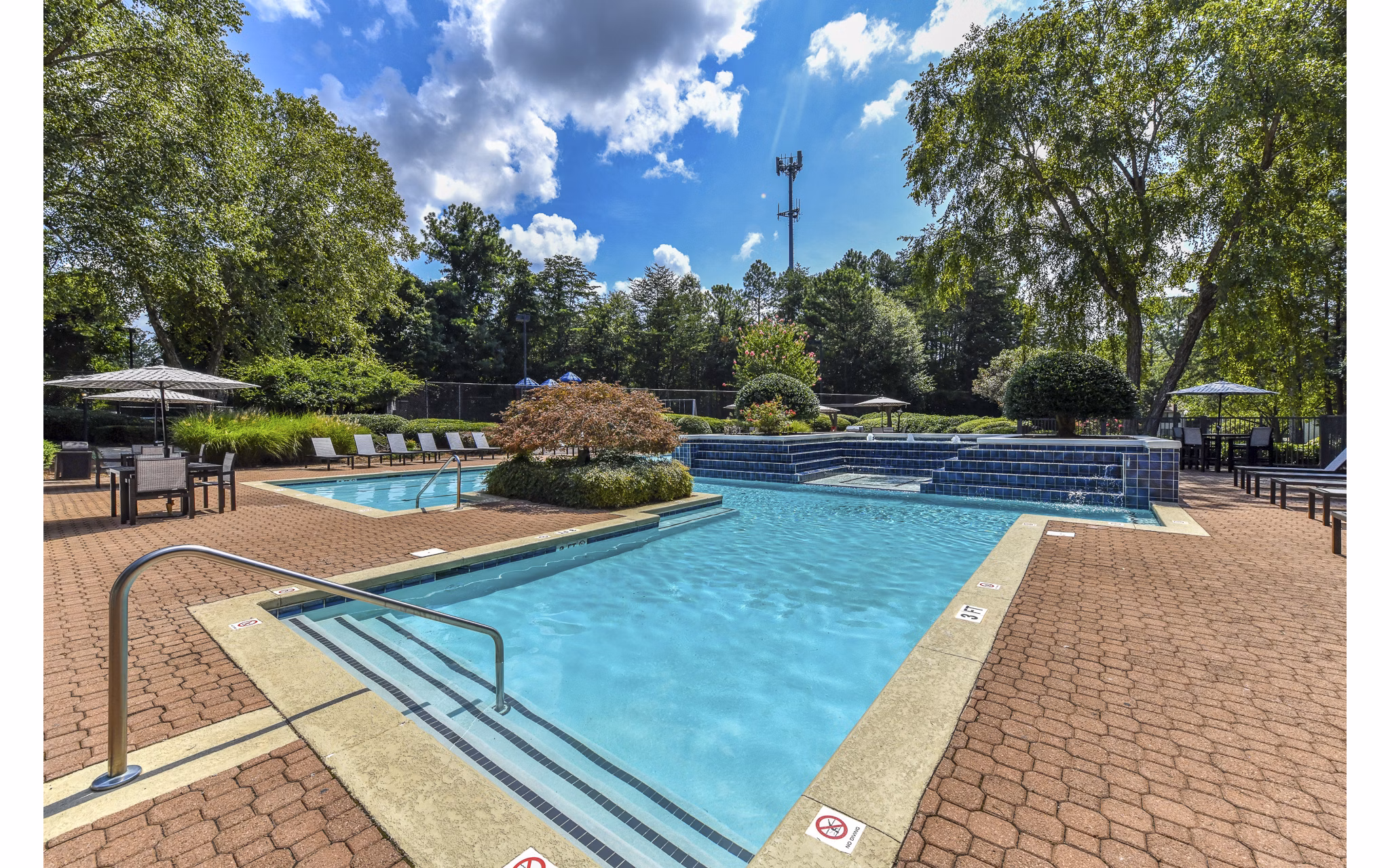 Outdoor pool area with lounge seating at Avana Chase Apartments