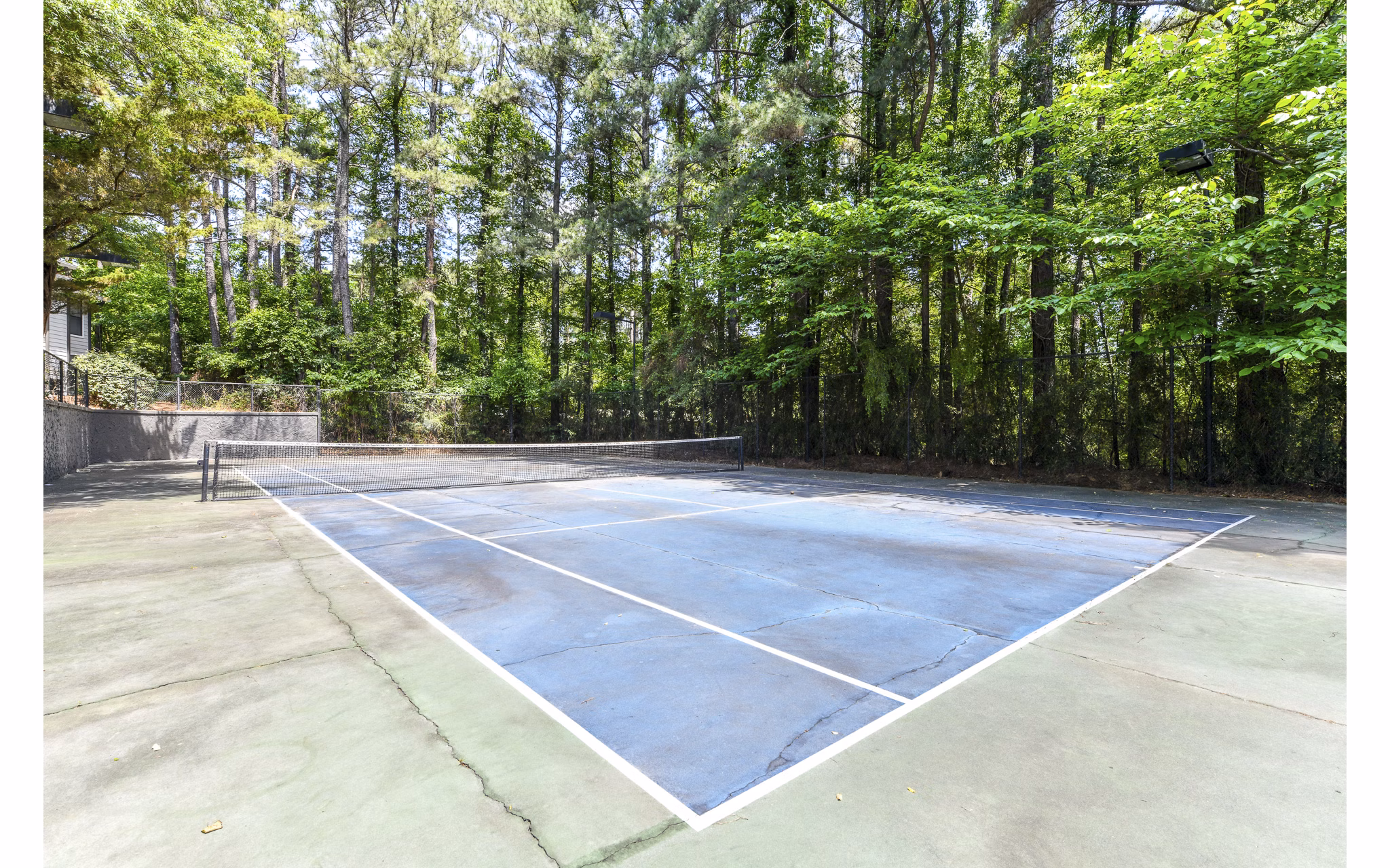 Outdoor sport court at Avana Court Apartments featuring basketball and tennis facilities
