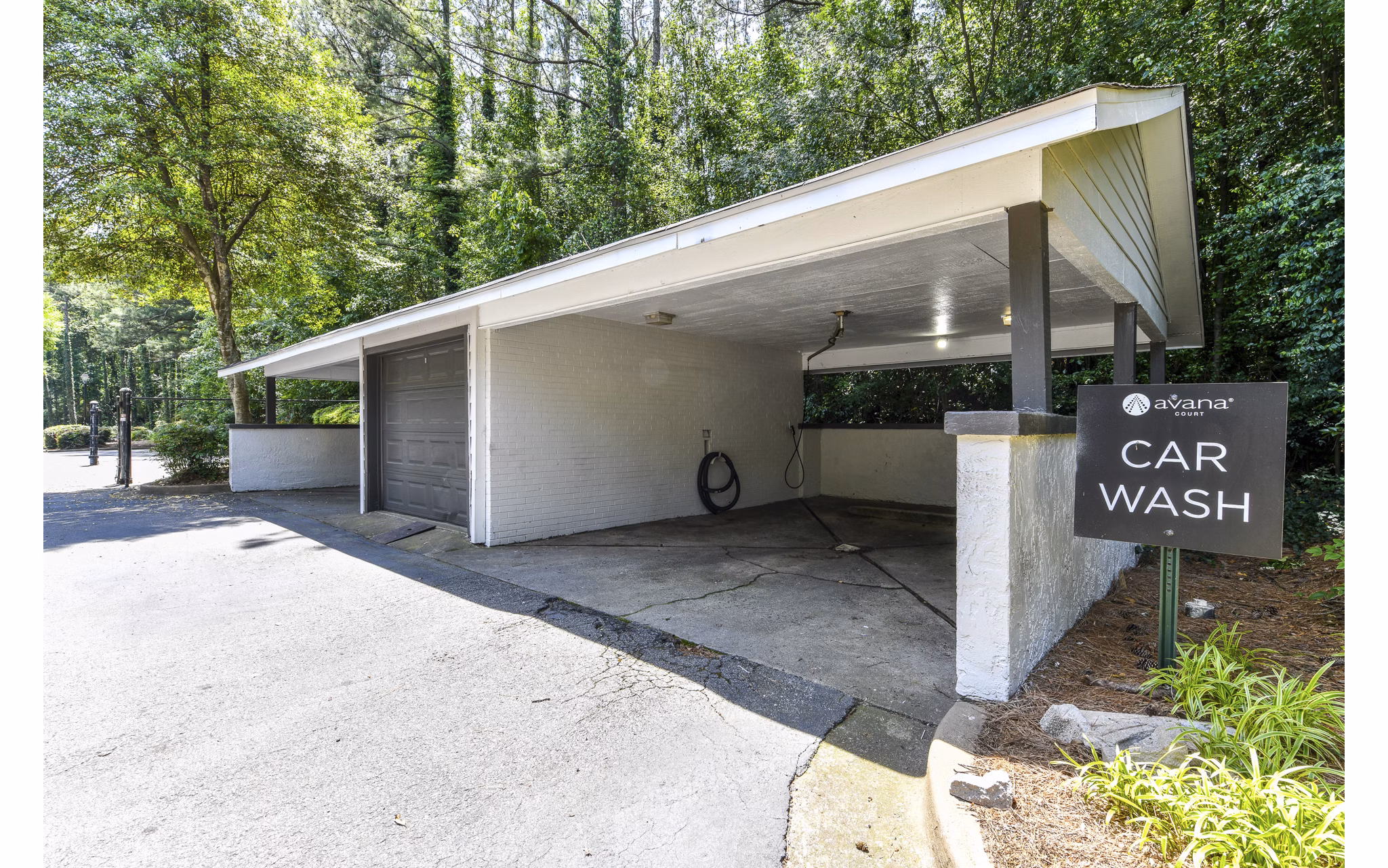 Car care station with washing bays at Avana Court Apartments offering convenient vehicle maintenance for residents