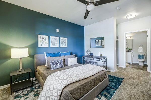 Cozy bedroom with modern decor at The Fletcher Southlands Apartments, featuring stylish furnishings and ample natural light