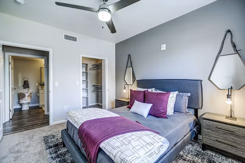 Modern bedroom with plush bedding and neutral tones at The Fletcher Southlands Apartments