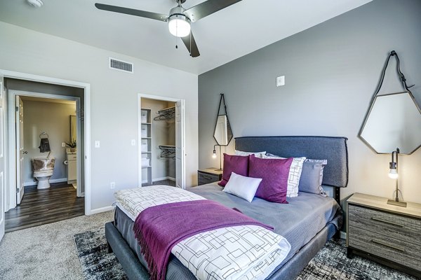 Modern bedroom with plush bedding and neutral tones at The Fletcher Southlands Apartments