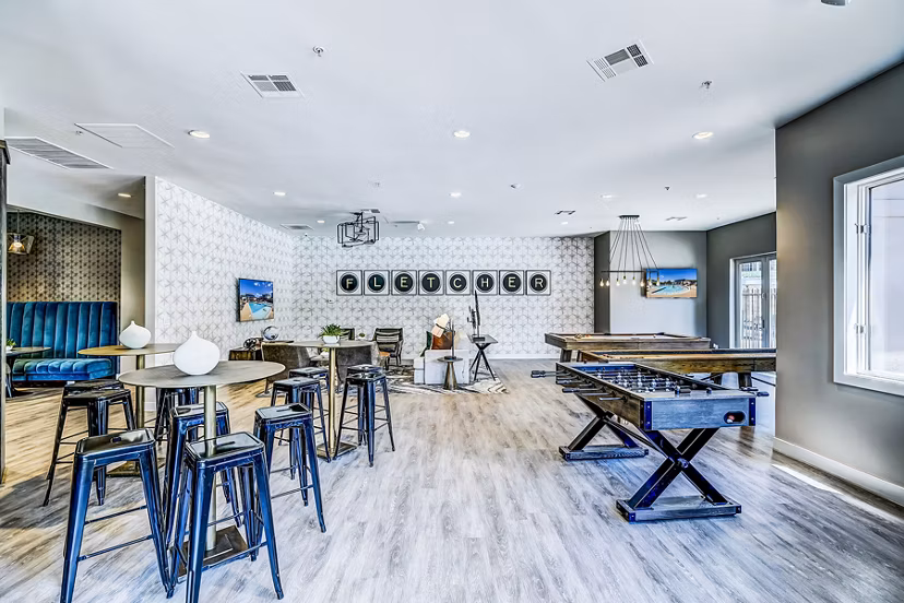 Game room with billiards and seating area at The Fletcher Southlands Apartments in Aurora, CO, offering fun recreational activities for residents