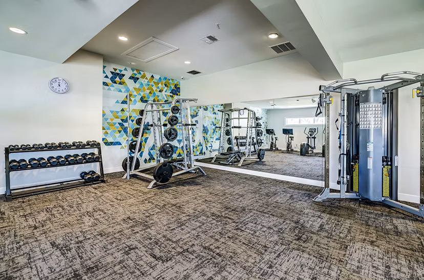 Fully equipped fitness center at The Fletcher Southlands Apartments with state-of-the-art gym machines and weights