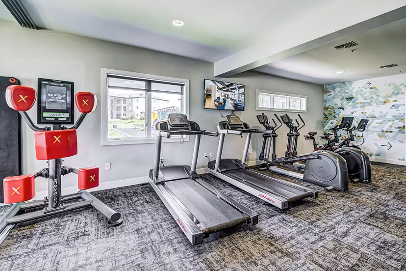 State-of-the-art fitness center at The Fletcher Southlands Apartments featuring modern exercise equipment and spacious workout areas