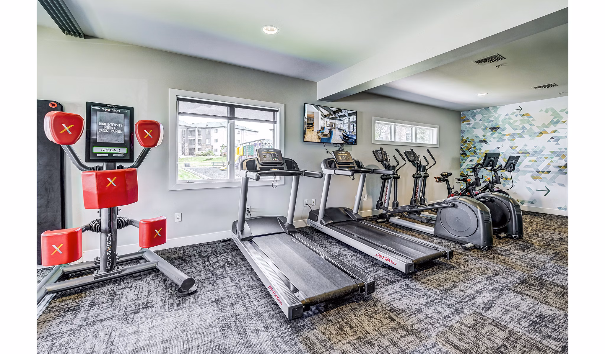 State-of-the-art fitness center at The Fletcher Southlands Apartments featuring modern exercise equipment and spacious workout areas