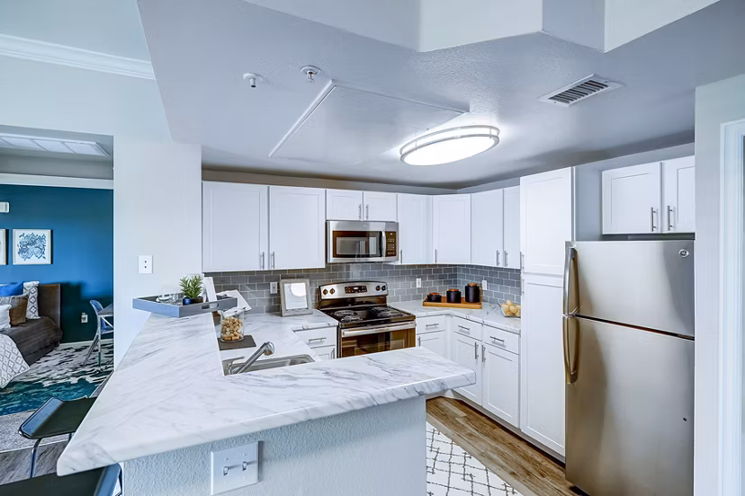 Modern kitchen with stainless steel appliances and granite countertops at The Fletcher Southlands Apartments, luxury living in Denver